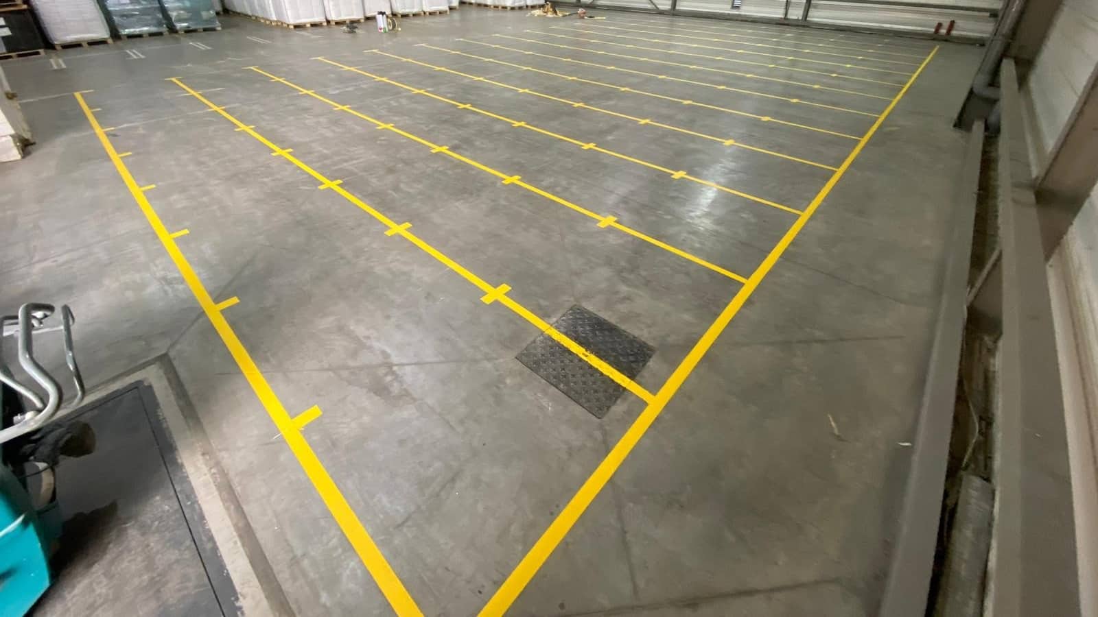 Marquage jaune au sol délimitant des zones de stockage dans un entrepôt logistique