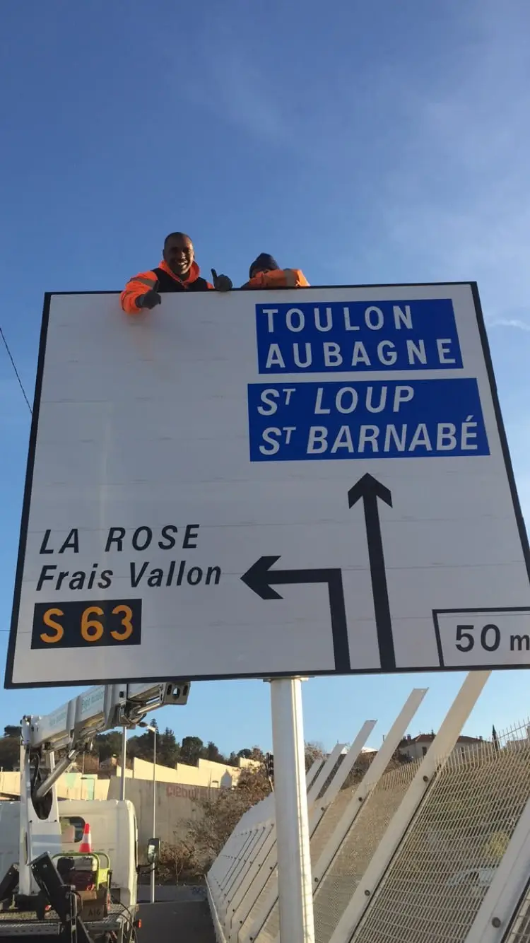 Salariés ASM posant un ensemble de panneaux directionnels en bord de voie
